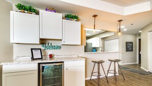 A kitchen with white cabinets, a built-in dishwasher, and a welcome sign. - Community Perks! Waterfront Lake Ozark Escape (Lake Ozark)