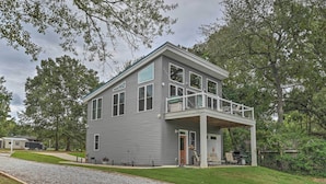 A two-story house with a covered porch and a small deck. - Waterfront Greenwood Getaway w/ Deck & Grill! (Greenwood)