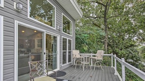 A deck with outdoor furniture and a glass door leading to a patio. - Waterfront Greenwood Getaway w/ Deck & Grill! (Greenwood)