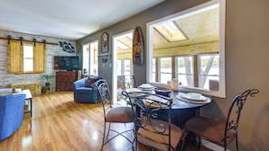 A dining area with a wooden table, metal chairs, and a large window. - Waterfront Ozarks Home w/ Hot Tub, Bar & Dock (Rocky Mount)