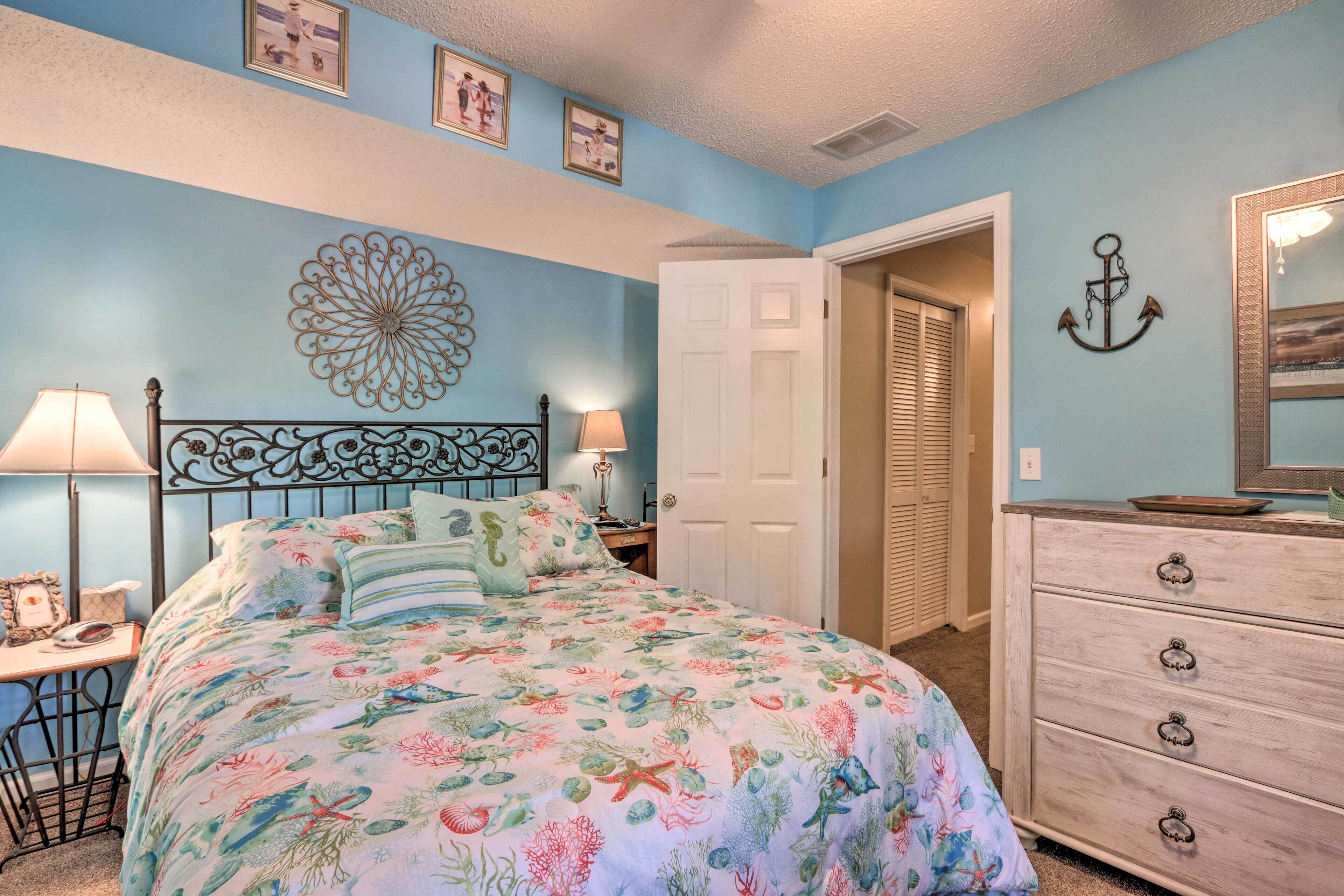 A bedroom with a bed, bedside tables, a dresser, and a door.