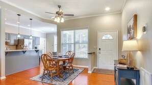 A dining area with a wooden table and chairs, a ceiling fan, and a window with blinds. - Lakefront Mccormick Gem: Deck & Golf Course Views (McCormick)