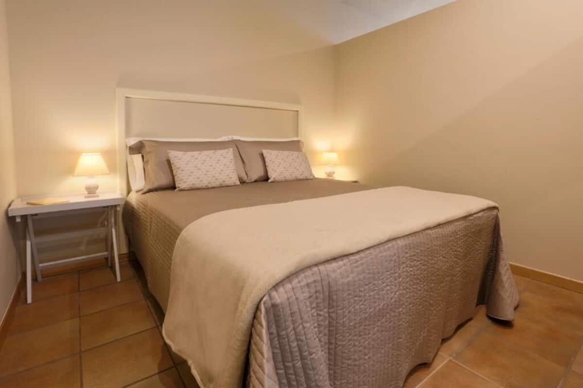 A bedroom with a bed, nightstands, and a small table.