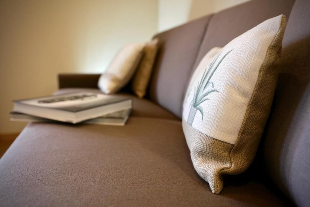 A brown sofa with a cushion featuring a leaf design.