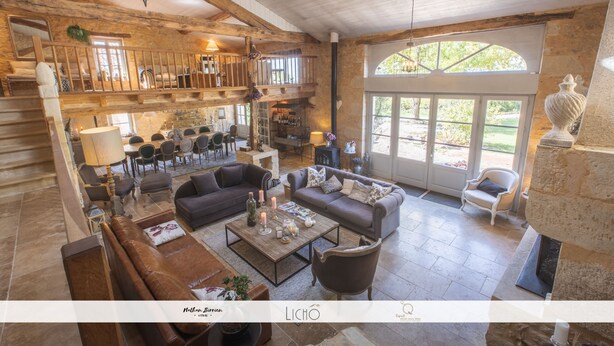 A spacious living area with a high ceiling, wooden beams, and a balcony overlooking a garden. - Maison des Quatre Saisons (Les Esseintes)