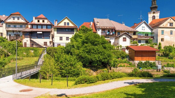 A residential area with houses, a church, and a small wooden structure.