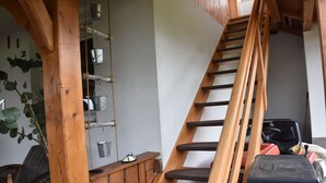 A wooden staircase with a handrail leading to a landing area.