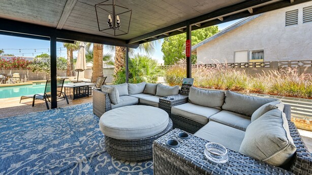 A covered outdoor seating area with a pool in the background. - Yuma Vacation Rental w/ Private Pool & Patio! (Yuma)
