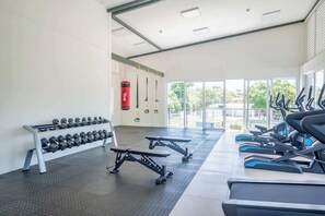 A gym with treadmills, dumbbells, and resistance bands.