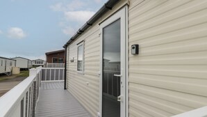 A mobile home with a balcony, a sliding door, and a window. - Rowan Court 2 (Scarborough)