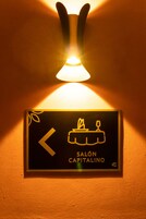 Señal direccional para 'SALÓN CAPITALINO' con una flecha apuntando a la izquierda e icono de vela.