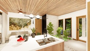 A modern kitchen with a central island, a dining area with a sofa, and a large window offering a view of greenery. - Best Villa (La Fortuna)