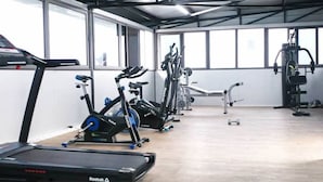 Une salle de sport équipée de tapis de course, de vélos elliptiques et de matériel de musculation.