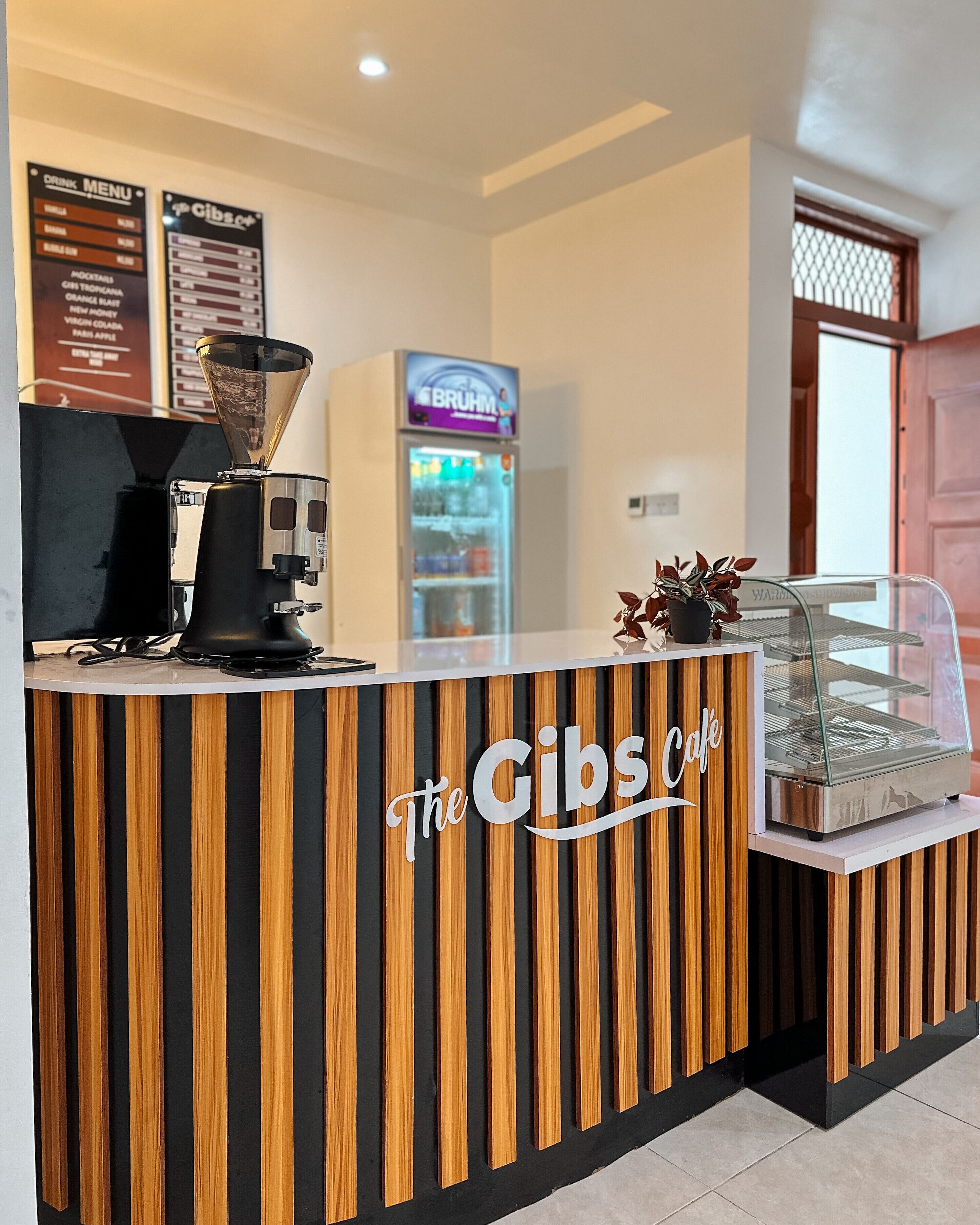 En receptionsdisk med kaffemaskine, menutavle og køledisk.