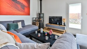 Moderni olohuone, jossa on sohva, sohvapöytä ja takka.