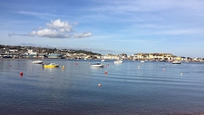A coastal town with boats on calm waters, buildings in the background, and a clear sky. - Coastal retreat Converted Stables, ,  close to Maidencombe beach & pubs. (Stokeinteignhead Torquay,)