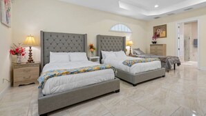 Une chambre avec deux lits, une table de chevet et une commode.