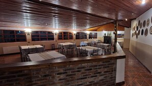 Un restaurante con paredes de ladrillo, techo de madera y mesas dispuestas para comer.