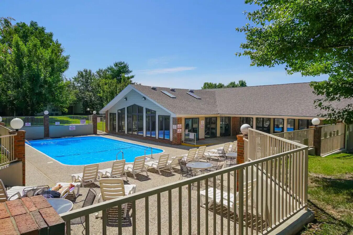 A swimming pool with lounge chairs and a covered patio area.