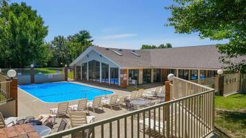 A swimming pool with lounge chairs and a covered patio area.