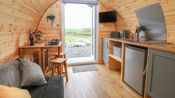 Un intérieur chaleureux et rustique, avec un espace repas, une cuisine et un coin salon.