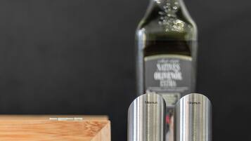 Eine Küchenarbeitsplatte mit einer Olivenölflasche, zwei Salzstreuern und einer Holzkiste.