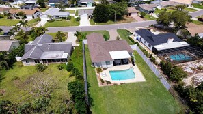 A residential area with houses, a swimming pool, and a well-maintained lawn. - BOOK NOW & SAVE!! CLOSE TO IMG!  Base Rent has been REDUCED by 20 percent!  West Bradenton Pool Home |The Tranquila House | Heated Pool | Near Anna Maria Island | Sleeps 6 (Bradenton)