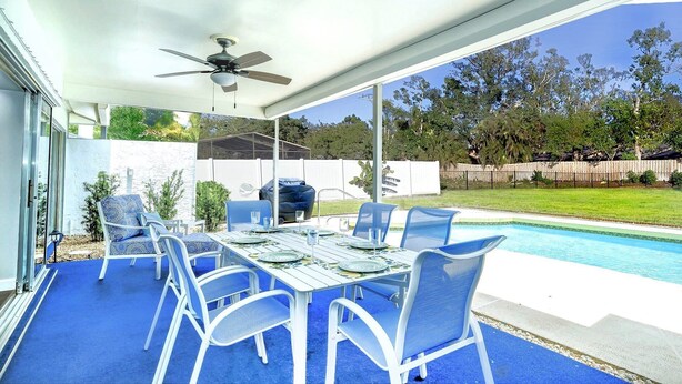 Eine Außenpatio mit Pool, überdachter Sitzgelegenheit und Deckenventilator.