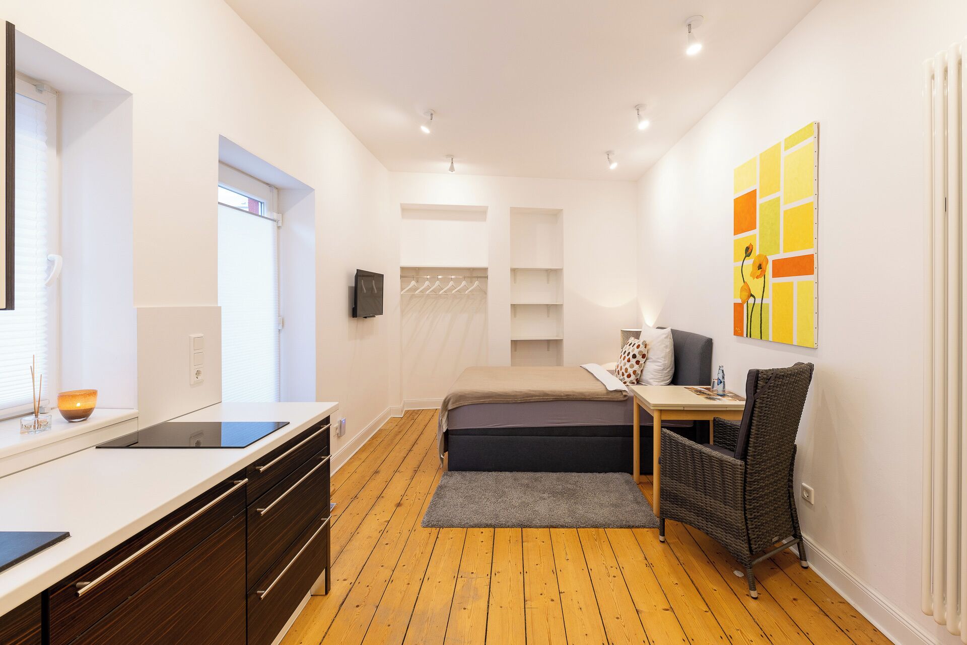 Ein modernes Schlafzimmer mit Bett, Nachttisch und Fernseher.