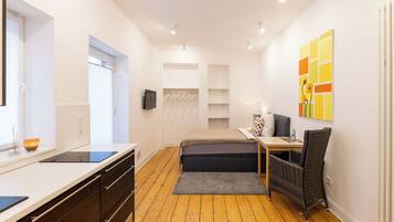 Ein modernes Schlafzimmer mit Bett, Nachttisch und Fernseher.