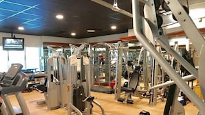 A gym with various exercise machines, treadmills, and weightlifting equipment. - Peninsula Links B102 (Gulf Shores)