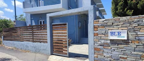 A modern two-story building with a stone facade and a wooden gate.