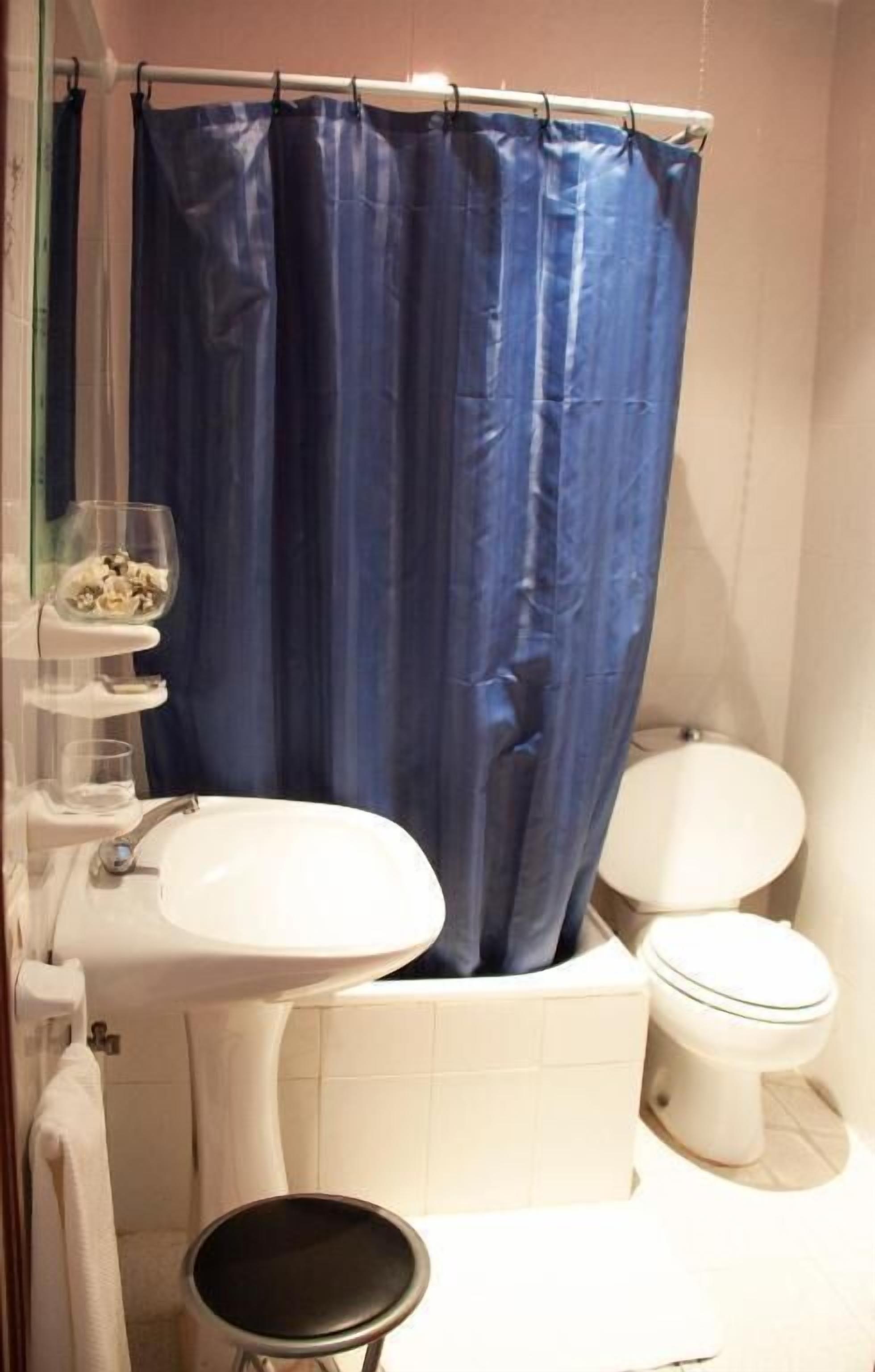 A bathroom with a white sink, a toilet, and a bathtub.