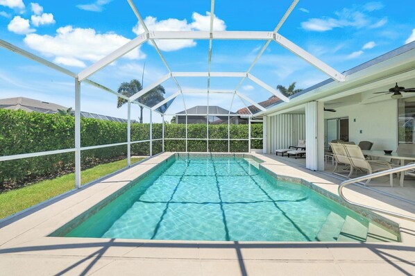 Una piscina cubierta al aire libre con un patio y mobiliario.