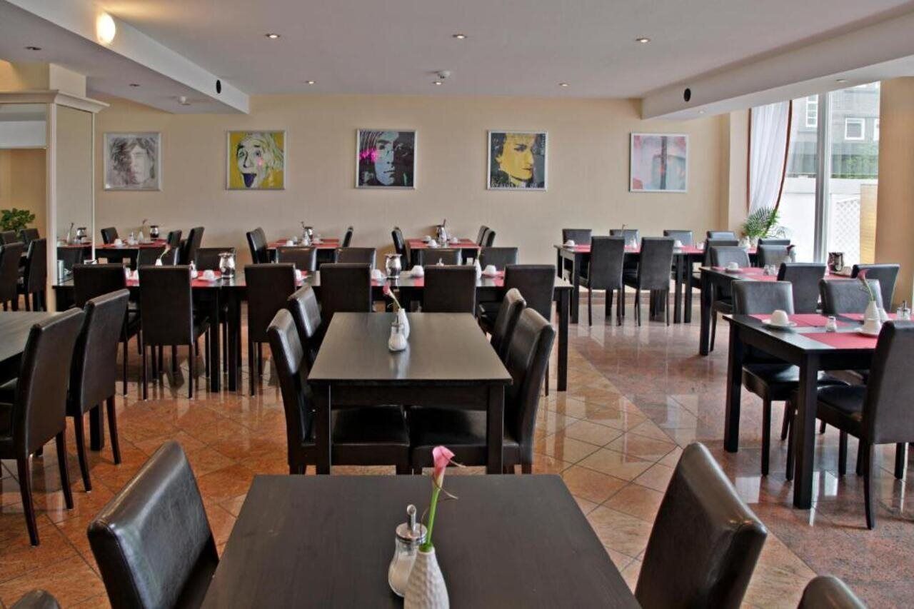 Ein Restaurant mit mehreren Tischen und Stühlen, ansprechend und großzügig angeordnet.