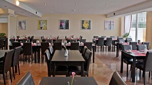 Un restaurant doté de nombreuses tables et chaises, disposées dans un espace vaste et bien aménagé.