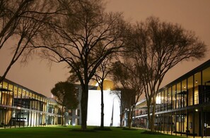 Un edificio moderno con fachada de vidrio y una estructura central iluminada.