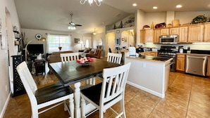A spacious kitchen with wooden cabinets, a central island, and modern appliances.