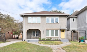 A two-story house with a brick facade, a front porch, and a small garden. - Museum District - 3Br/2Ba Sunny apartment with King Bed (Houston)