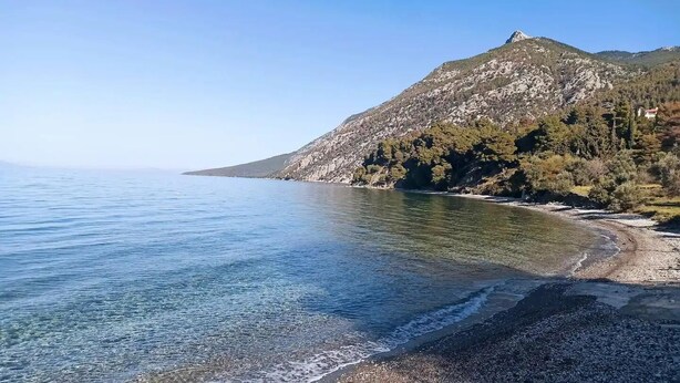 A coastal landscape with a clear view of the sea, a rocky shoreline, and a mountain in the background. - Calypso Villa with Jacuzzi Pool & Sea View (Dafni)