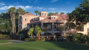 Stunning building with a classic design, surrounded by lush greenery and a golf course.