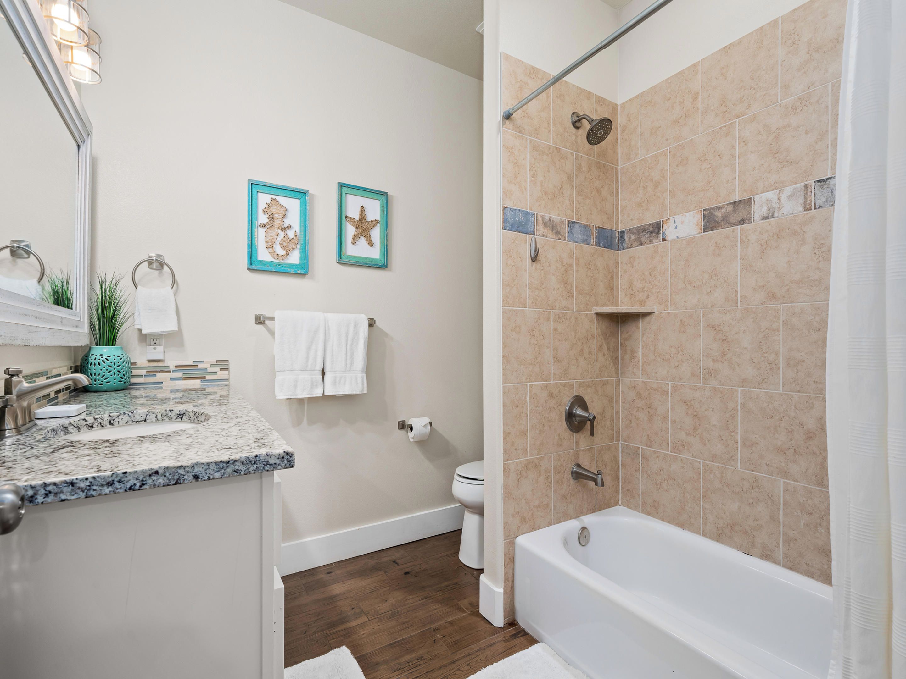 Un baño con lavabo de mármol, bañera y zona de ducha.