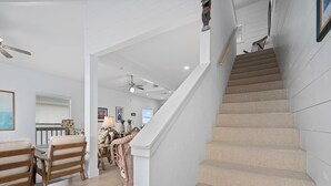 A staircase with beige carpeted steps leading to a landing.