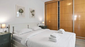 A hotel room with a bed, bedside tables, a wardrobe, and artwork on the wall. - Stunning Rooftop Condo with Sea Views in Fuengirola (Fuengirola)