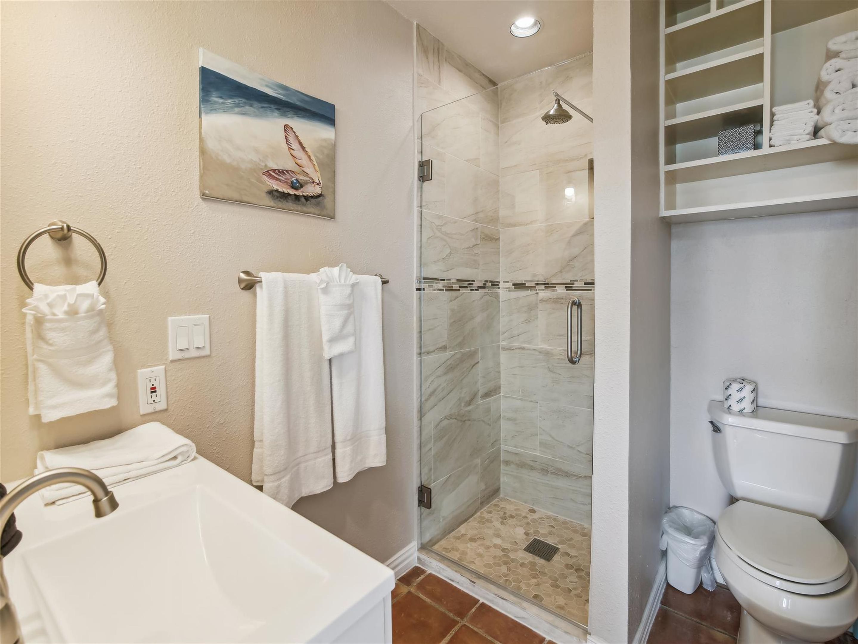 A bathroom with a shower, toilet, and bathtub.