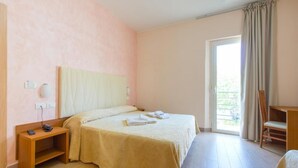 Une chambre d’hôtel avec un lit, une table de chevet et une chaise.