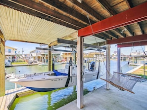 Moored at the dock, the TX 6088 CM boat offers a serene view of the surrounding buildings and water.