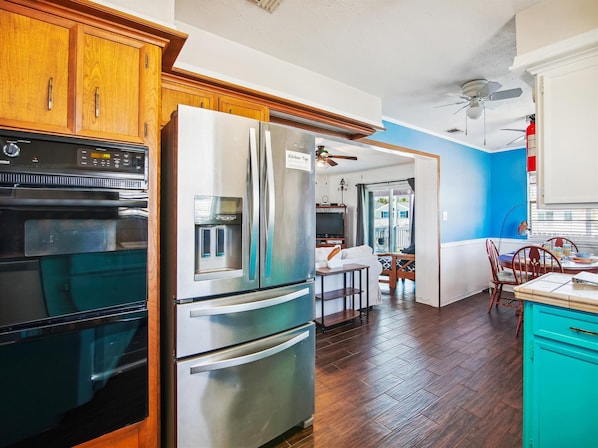 Enjoy cooking in this well-equipped kitchen with a refrigerator, oven, and dining area.