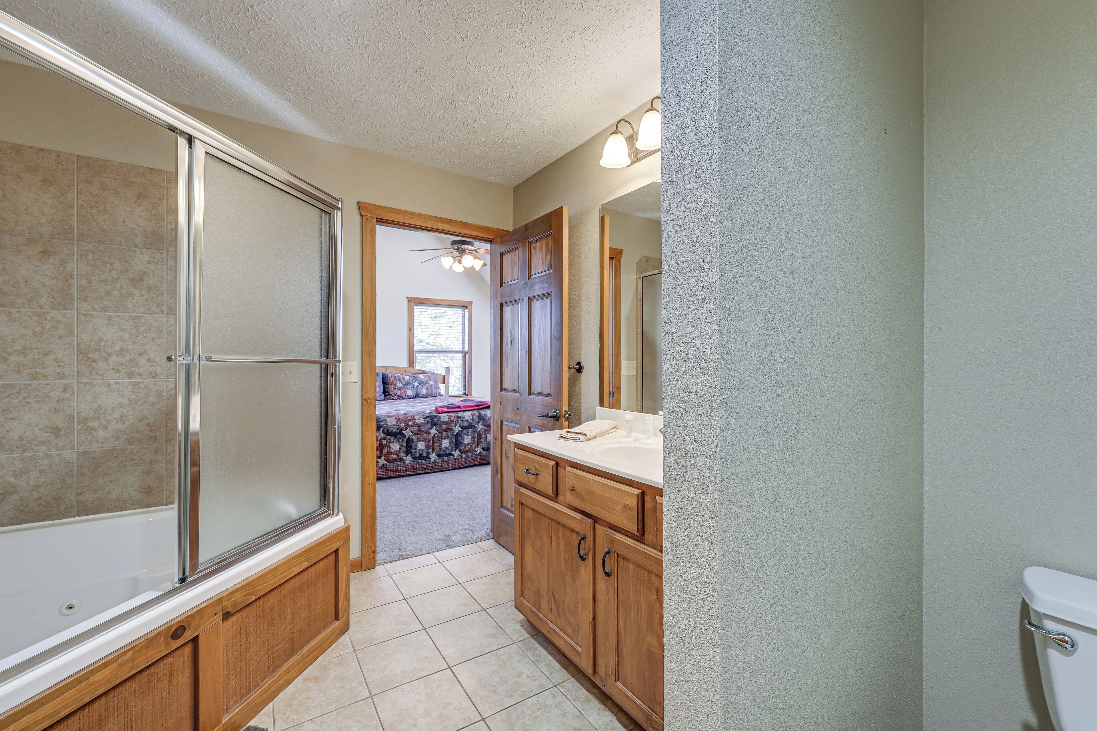 A bathroom with a shower, toilet, and vanity.