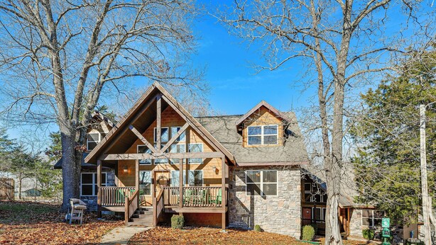 A two-story log cabin with a front porch, stone exterior, and a clear sky. - Families Welcome! Branson Resort-style Getaway (Branson)